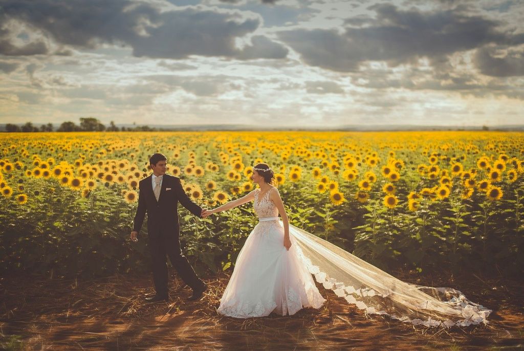 Un couple de marié devant un champ de tournesol
